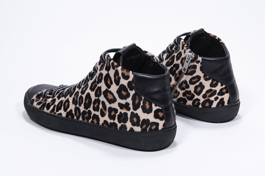 Vue de trois quarts arrière d'une chaussure de sport à imprimé léopard avec tige en cuir de veau pleine fleur, fermeture à glissière intérieure et semelle noire.
