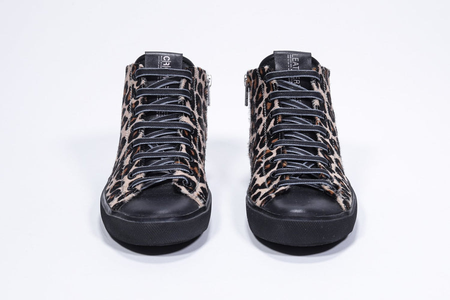 Vue de face d'une chaussure de sport à imprimé léopard avec tige en cuir de veau pleine fleur, fermeture à glissière intérieure et semelle noire.